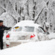 A man clears snow from his car in Moscow. Photo: AP